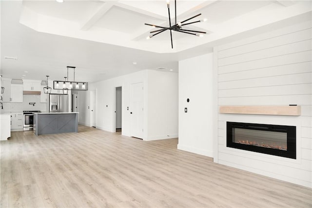 1053 Beaner Hollow Rd, Brighton Twp, PA 15009 - unfurnished living room featuring a chandelier, light wood-style flooring, a glass covered fireplace, and recessed lighting