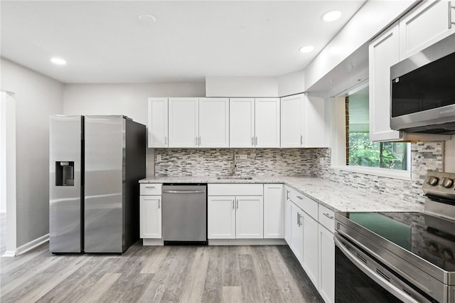 1014 Deerfield Dr, Elizabeth Twp/Boro, PA 15037 - kitchen featuring appliances with stainless steel finishes, light wood-type flooring, white cabinetry, light stone counters, and tasteful backsplash
