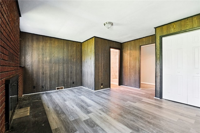 1014 Deerfield Dr, Elizabeth Twp/Boro, PA 15037 - unfurnished bedroom with wood finished floors, wood walls, and a brick fireplace