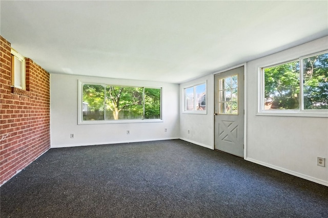 1014 Deerfield Dr, Elizabeth Twp/Boro, PA 15037 - empty room with healthy amount of natural light, brick wall, and dark carpet