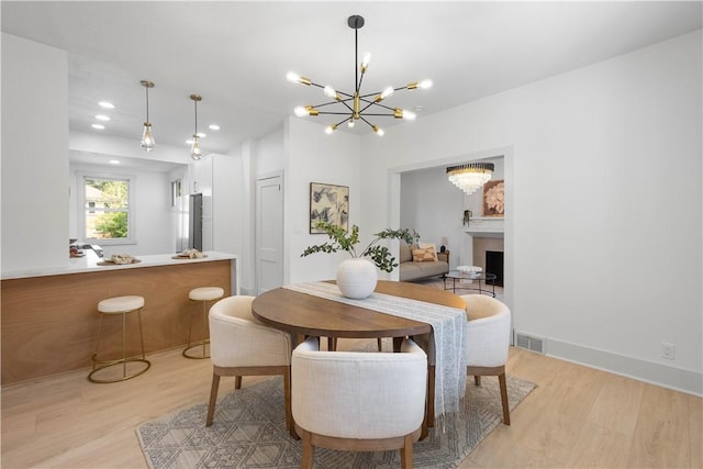 3246 Piedmont Ave, Dormont, PA 15216 - dining area with light wood finished floors, a chandelier, a fireplace, and recessed lighting