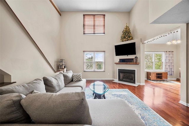 121 Fairway Landings Dr, Cecil, PA 15317 - living room with wood finished floors, a fireplace with flush hearth, and a towering ceiling