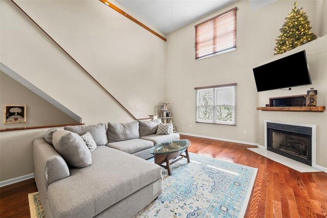 121 Fairway Landings Dr, Cecil, PA 15317 - living area featuring a fireplace with flush hearth, wood finished floors, and a towering ceiling