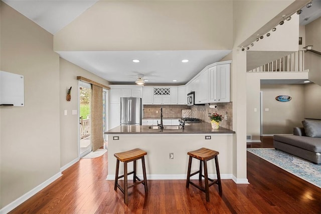 121 Fairway Landings Dr, Cecil, PA 15317 - kitchen featuring stainless steel appliances, a peninsula, white cabinets, dark wood-style floors, and high vaulted ceiling