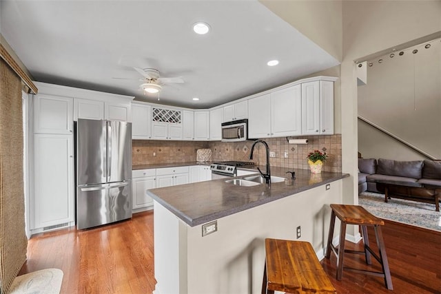121 Fairway Landings Dr, Cecil, PA 15317 - kitchen with appliances with stainless steel finishes, a peninsula, a ceiling fan, a breakfast bar area, and white cabinetry