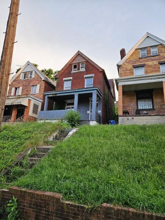 324 Moore Ave, Knoxville, PA 15210 - view of front of home featuring brick siding and a chimney