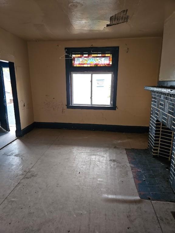 324 Moore Ave, Knoxville, PA 15210 - unfurnished living room featuring a tile fireplace and plenty of natural light