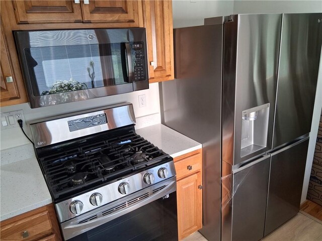 4977 Meadow Park Dr, Whitehall, PA 15236 - kitchen with appliances with stainless steel finishes, brown cabinetry, and light stone countertops
