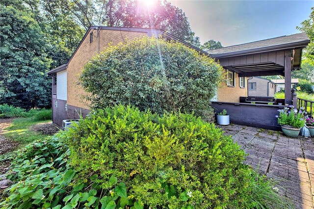 511 New Haven Dr, Hempfield Twp, PA 15601 - view of side of home featuring brick siding, a patio, and board and batten siding