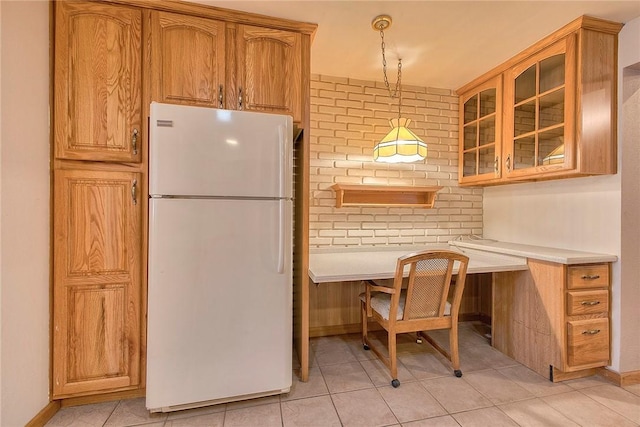511 New Haven Dr, Hempfield Twp, PA 15601 - kitchen with freestanding refrigerator, glass insert cabinets, light tile patterned floors, and built in desk