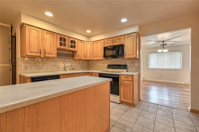 511 New Haven Dr, Hempfield Twp, PA 15601 - kitchen with black appliances, light tile patterned floors, light countertops, backsplash, and glass insert cabinets
