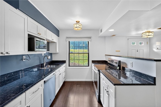 1152 Pennsbury Blvd, Pennsbury, PA 15205 - kitchen featuring stainless steel appliances, white cabinetry, dark wood finished floors, a peninsula, and dark stone counters