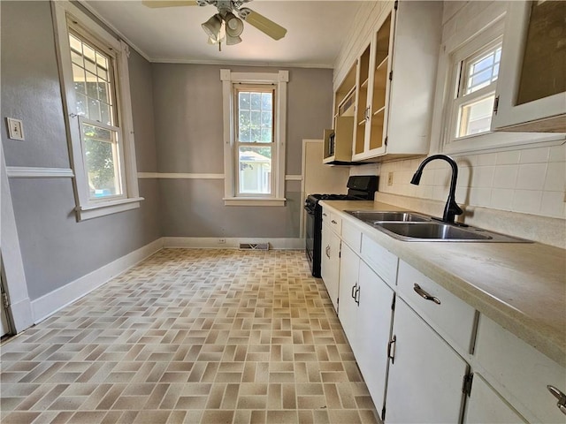 1908 6th Ave, Beaver Falls, PA 15010 - kitchen featuring black gas range oven, ceiling fan, backsplash, brick patterned flooring, and ornamental molding