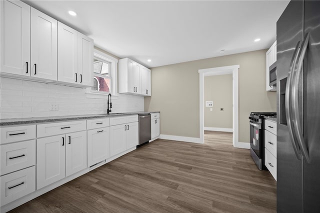 1317 Indiana Ave, Monaca, PA 15061 - kitchen featuring stainless steel appliances, tasteful backsplash, dark wood-style flooring, white cabinetry, and light stone counters