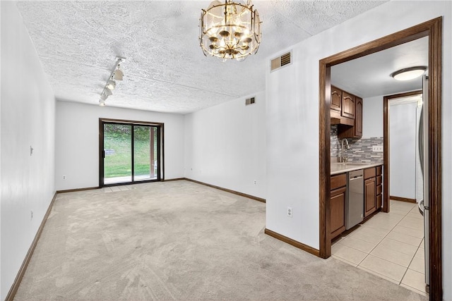 2011 Thornberry Dr, Ross Twp, PA 15237 - unfurnished living room featuring a textured ceiling, a chandelier, rail lighting, and light colored carpet
