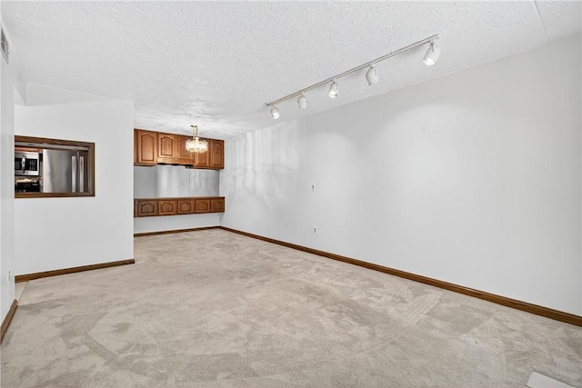 2011 Thornberry Dr, Ross Twp, PA 15237 - empty room with a textured ceiling, light colored carpet, a chandelier, and rail lighting