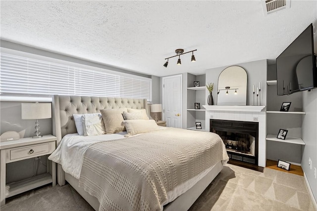 555 Madison St, Mccandless, PA 15237 - bedroom featuring a tiled fireplace, light carpet, and a textured ceiling