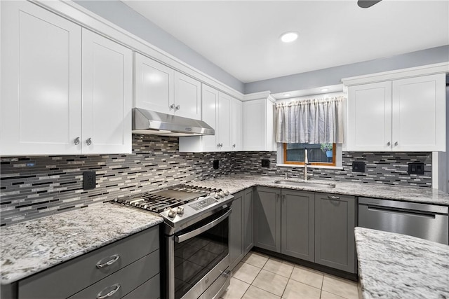 1615 Wicklines Ln, Troy Hill, PA 15212 - kitchen featuring stainless steel appliances, under cabinet range hood, gray cabinets, light tile patterned floors, and backsplash