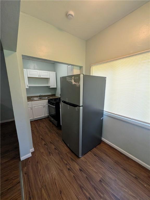1310 Pirl St, Mckeesport, PA 15132 - kitchen featuring appliances with stainless steel finishes, dark wood-style flooring, white cabinets, and dark countertops