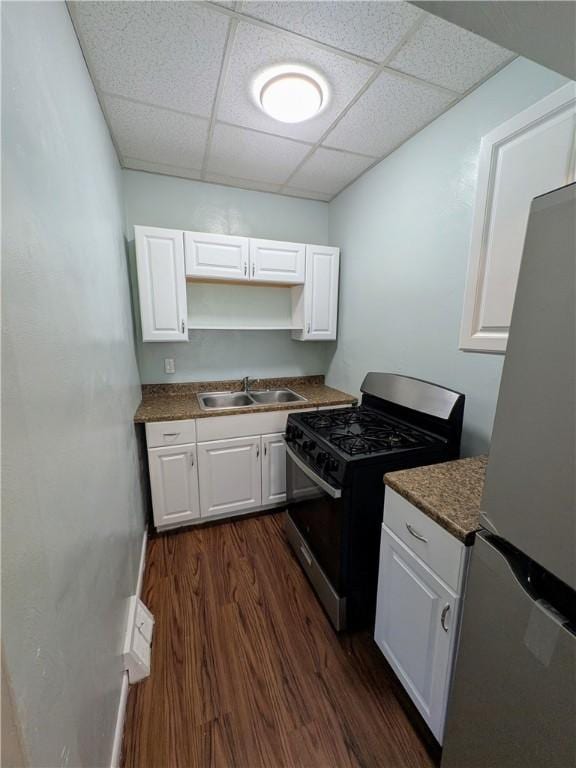 1310 Pirl St, Mckeesport, PA 15132 - kitchen featuring gas range, freestanding refrigerator, a paneled ceiling, white cabinets, and dark wood-style flooring