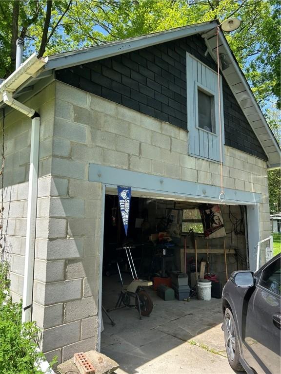 109 W Ridge Ave, Sharpsville, PA 16150 - view of side of home featuring concrete block siding, a garage, and driveway