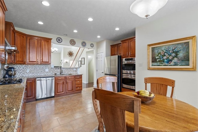 304 Horizon Dr, Monroeville, PA 15146 - kitchen with appliances with stainless steel finishes, tasteful backsplash, recessed lighting, light stone counters, and brown cabinets