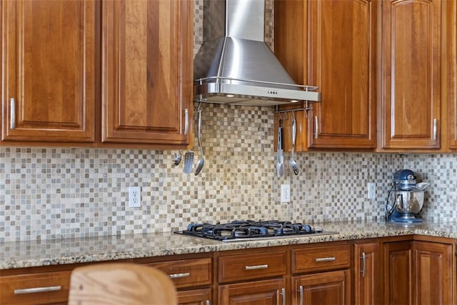 304 Horizon Dr, Monroeville, PA 15146 - kitchen featuring wall chimney range hood, stainless steel gas stovetop, brown cabinets, backsplash, and light stone counters