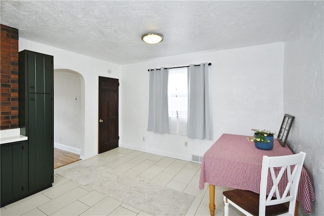 404 Emerson, Munhall, PA 15120 - dining space featuring arched walkways, light tile patterned floors, and a textured ceiling