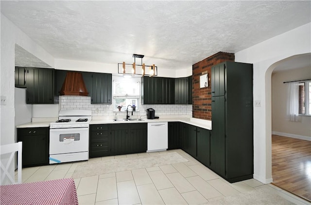 404 Emerson, Munhall, PA 15120 - kitchen featuring white appliances, custom exhaust hood, arched walkways, light countertops, and decorative backsplash