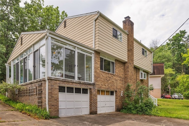 1449 Parkview Dr, Mccandless, PA 15101 - view of side of property with brick siding, a sunroom, a chimney, a garage, and concrete driveway
