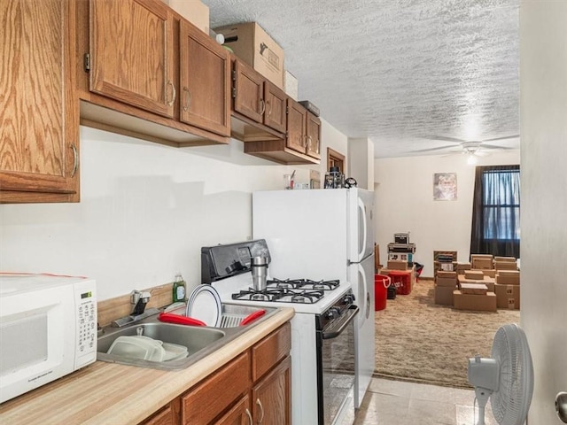 109 Ella St, Mckees Rocks, PA 15136 - kitchen with gas range oven, white microwave, light carpet, a textured ceiling, and brown cabinets