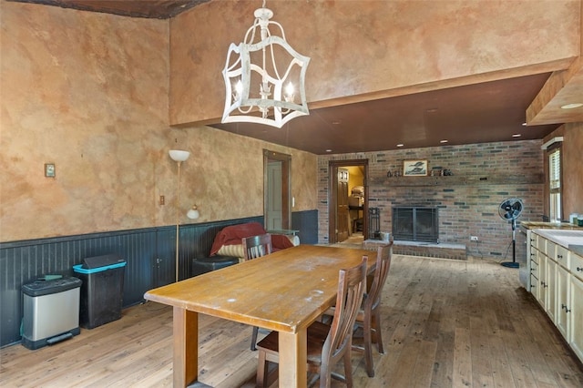 1345 N Tower Rd, Perry Twp, PA 16123 - dining room featuring hardwood / wood-style floors, wainscoting, a brick fireplace, and a chandelier