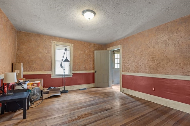 1345 N Tower Rd, Perry Twp, PA 16123 - exercise room featuring a textured ceiling, hardwood / wood-style flooring, and wallpapered walls
