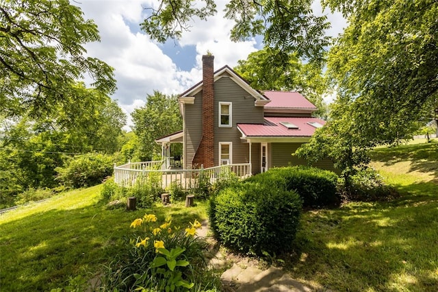 1345 N Tower Rd, Perry Twp, PA 16123 - back of house with a lawn, a chimney, a metal roof, and a wooden deck