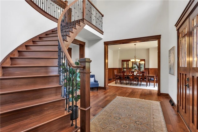 106 Orchard Dr, Pine Twp, PA 15044 - foyer entrance with a towering ceiling, hardwood / wood-style floors, stairs, a wainscoted wall, and a chandelier