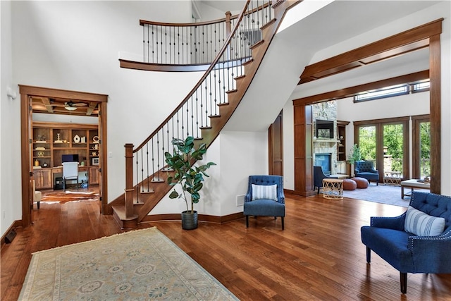 106 Orchard Dr, Pine Twp, PA 15044 - foyer with a high ceiling, wood-type flooring, a glass covered fireplace, stairs, and a ceiling fan