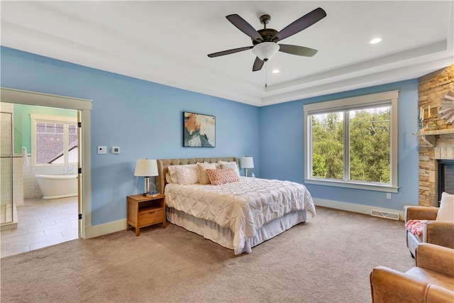 106 Orchard Dr, Pine Twp, PA 15044 - carpeted bedroom with a tray ceiling, a stone fireplace, recessed lighting, ensuite bath, and ceiling fan