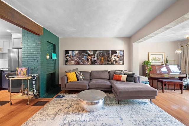 5671 Beacon St, Squirrel Hill, PA 15217 - living area featuring light wood-style floors, a brick fireplace, and a chandelier