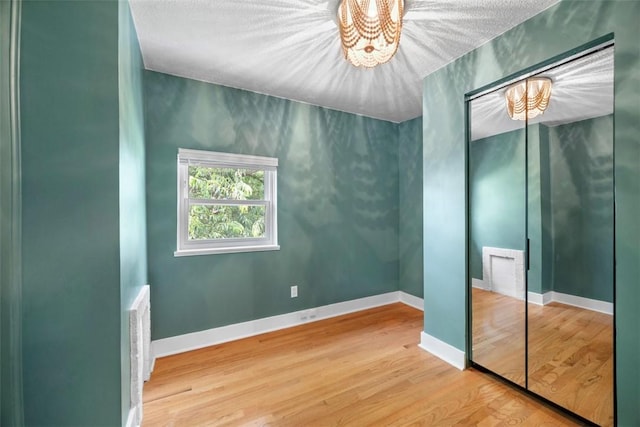 5671 Beacon St, Squirrel Hill, PA 15217 - unfurnished bedroom with a chandelier, a closet, and wood finished floors