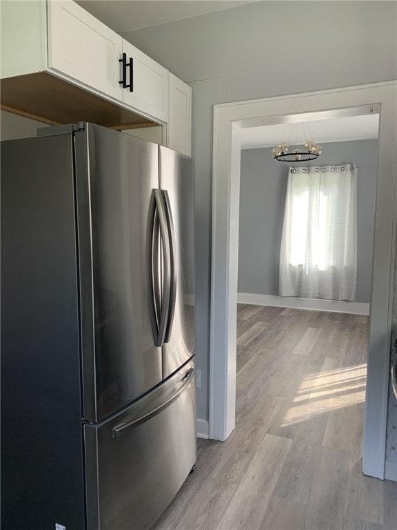1101 State Route 356, Allegheny Twp, PA 15656 - kitchen featuring freestanding refrigerator, a chandelier, light wood-style flooring, and white cabinetry