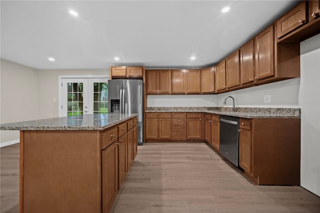 260 Stotler Rd, Penn Hills, PA 15235 - kitchen featuring appliances with stainless steel finishes, french doors, light wood-style floors, a center island, and brown cabinetry