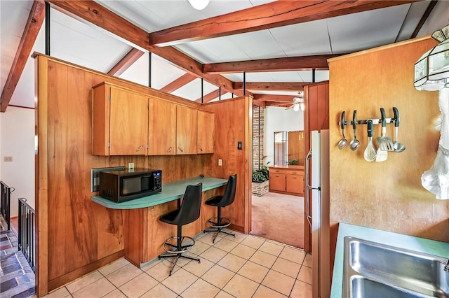 469 Koonce Rd, Hermitage, PA 16148 - kitchen with black microwave, built in desk, freestanding refrigerator, brown cabinets, and light tile patterned floors