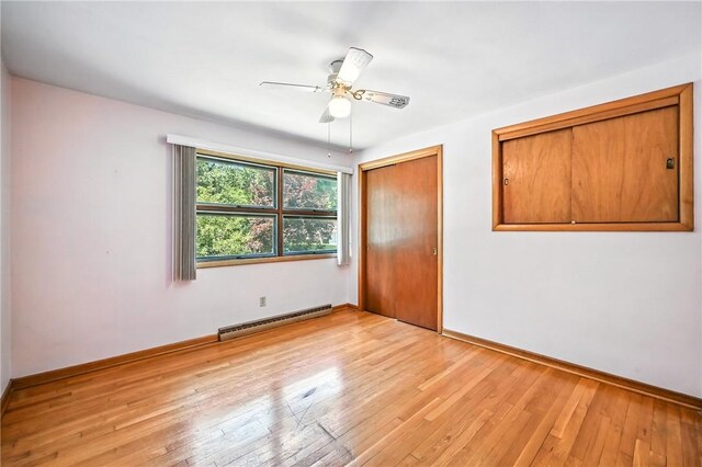 469 Koonce Rd, Hermitage, PA 16148 - unfurnished bedroom with a baseboard heating unit, light wood-style flooring, a closet, and ceiling fan