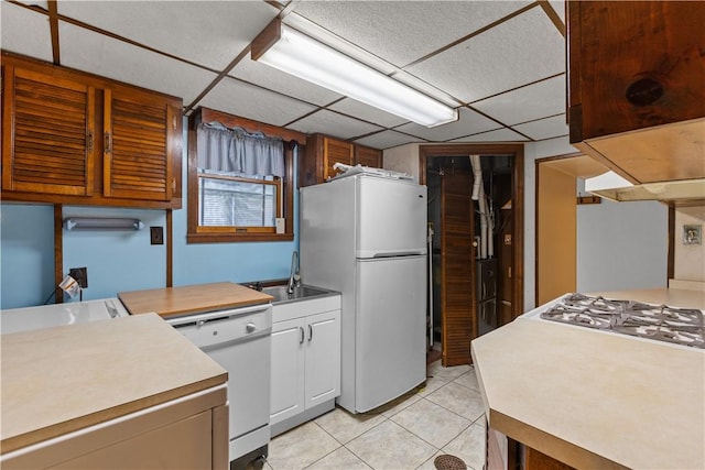 719 12th St, Pitcairn, PA 15140 - kitchen with white appliances, light tile patterned floors, white cabinets, a paneled ceiling, and light countertops