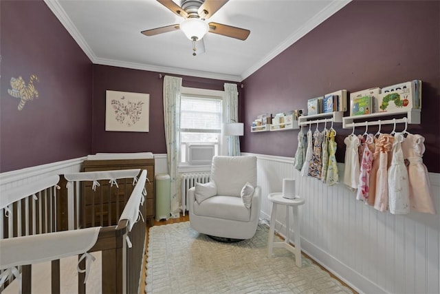 210 Ridge Ave, Ben Avon, PA 15202 - bedroom featuring wainscoting, radiator heating unit, ornamental molding, wood finished floors, and ceiling fan