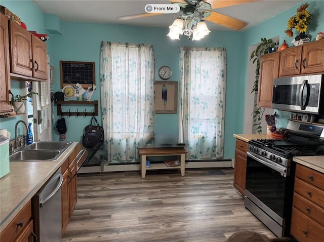 811 Cleveland Ave, Brackenridge, PA 15014 - kitchen with stainless steel appliances, a ceiling fan, brown cabinetry, wood finished floors, and light countertops