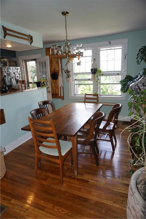 2430 Woodstock Ave, Swissvale, PA 15218 - dining area featuring a chandelier, wood-type flooring, and plenty of natural light