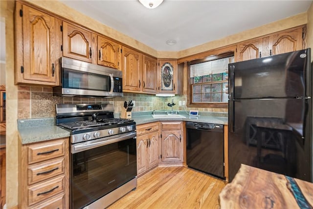 192 Glenfield Dr, Penn Hills, PA 15235 - kitchen featuring black appliances, light wood-type flooring, light countertops, backsplash, and brown cabinetry