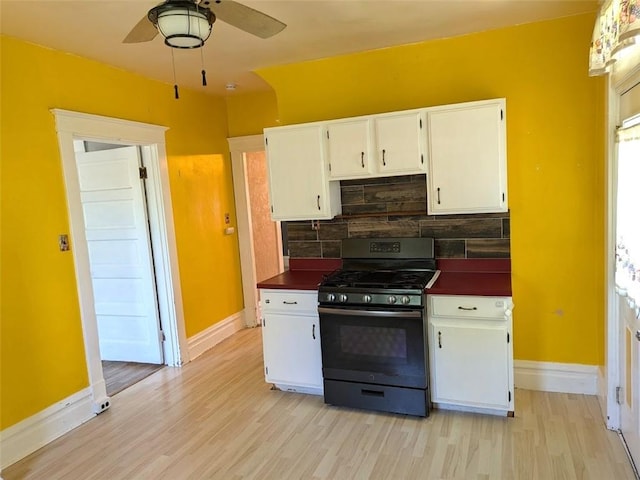 413 N 3rd St, Jeannette, PA 15644 - kitchen featuring gas range, dark countertops, ceiling fan, light wood-style floors, and white cabinets