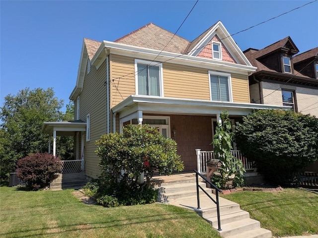 413 N 3rd St, Jeannette, PA 15644 - american foursquare style home featuring a porch, a front lawn, and roof with shingles